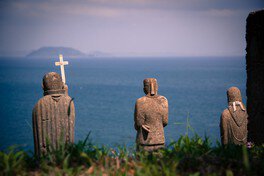 談合島(湯島)を眺める３体の石像